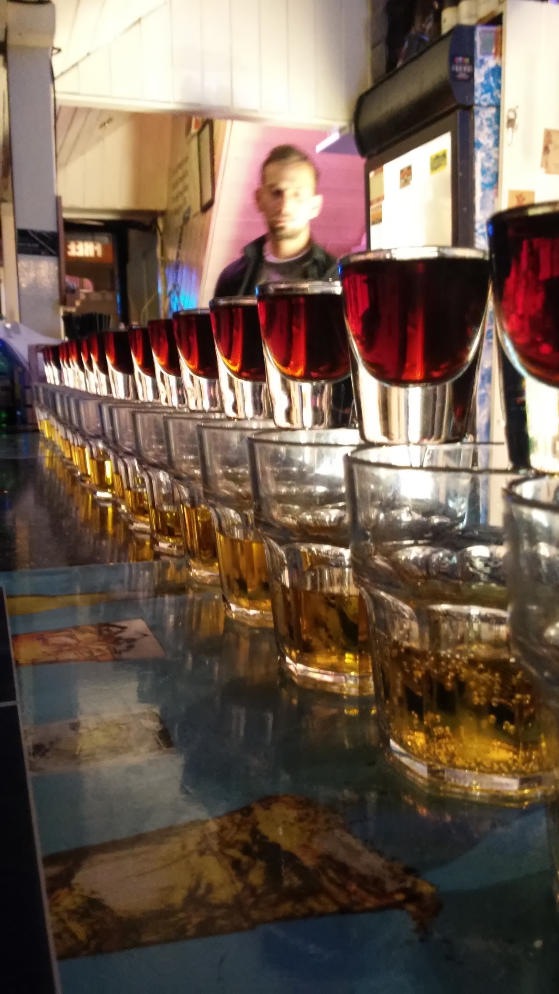 A row of shots and mixers lined up along the bar top.